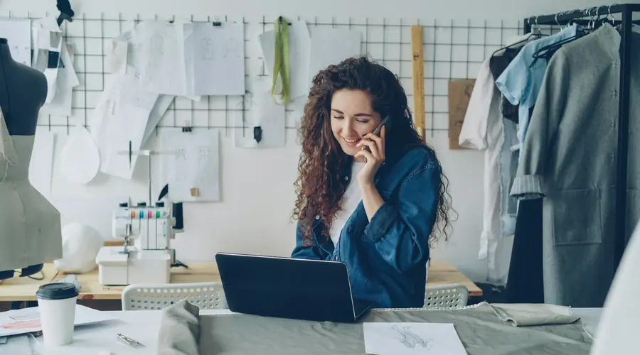 Ondernemer aan de telefoon achter haar laptop